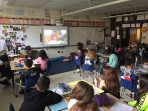 A class of primary students in front of a large screen participating in Arctic Live